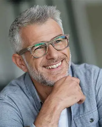 Photo d'Alain, homme d'un âge mûr avec des cheveux gris et des lunettes. Alain sourit.